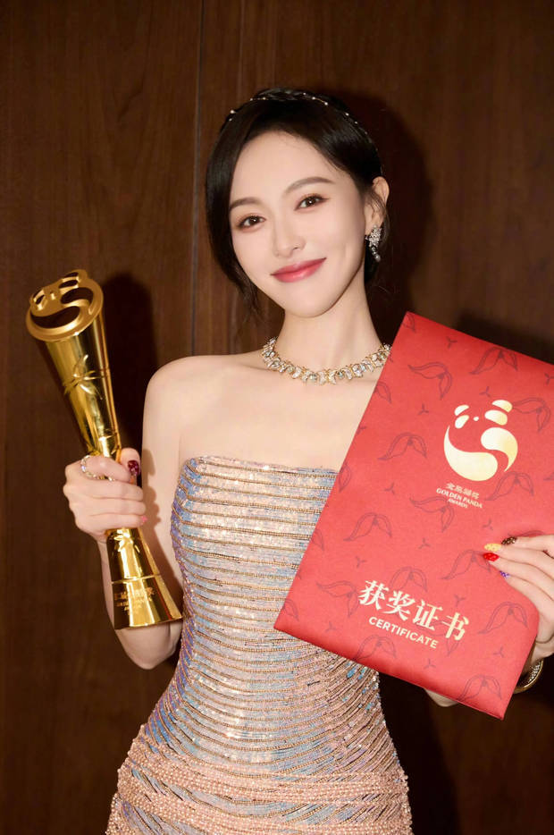 唐嫣拿着奖杯，笑容甜美。