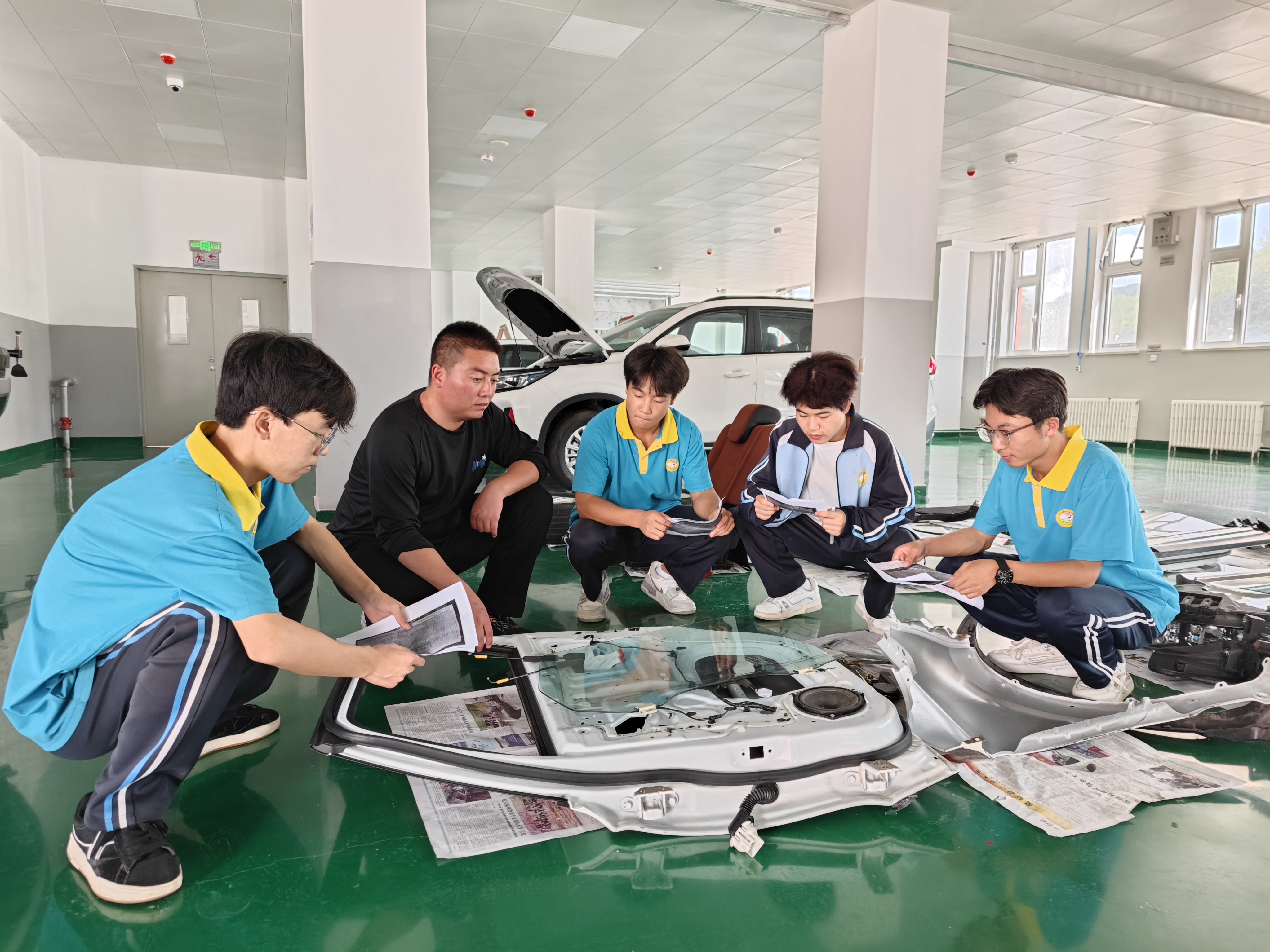 图为灵台县职业中专学生在津南区援建的汽车实训基地内学习汽车维修知识