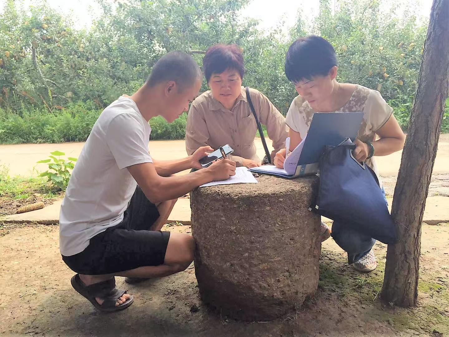 龚丽君（中）与同事开展入户走访