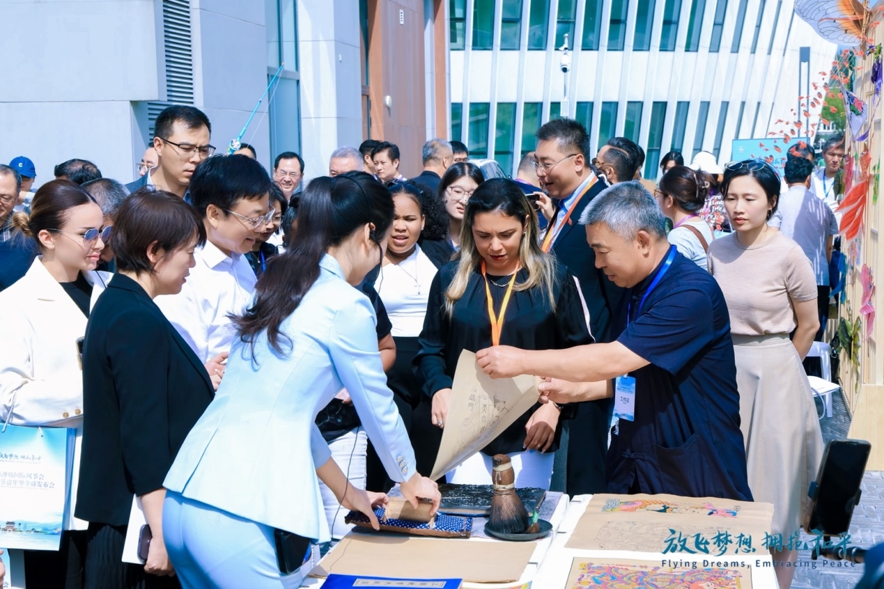 （参会嘉宾学习杨家埠木版年画的制作技巧）