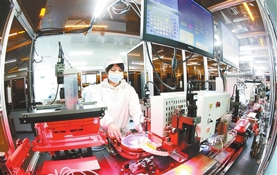 位于信丰县高新技术产业园区的江西信芯半导体有限公司，工人在5G功率保护芯片及IC封测项目生产线上操作。