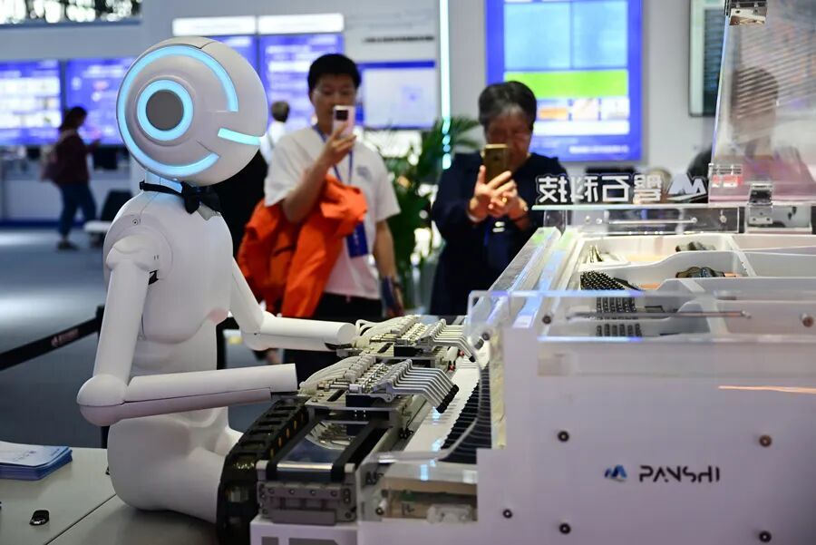 2025年4月26日，观众在第三届中国（安徽）科技创新成果转化交易会上观赏一款弹钢琴的机器人。新华社记者 周牧 摄