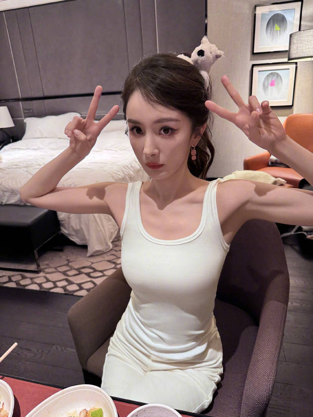 杨幂穿白色紧身背心吃饭，好身材一览无余。