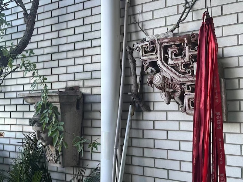 阳台上两个建筑构件，一个是中国传统民居的木雕牛腿，一个来自纽约苏荷区。