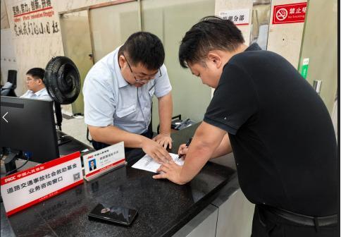 (人保财险服务网点工作人员指导申请人填写资料。中国人保财险供图)