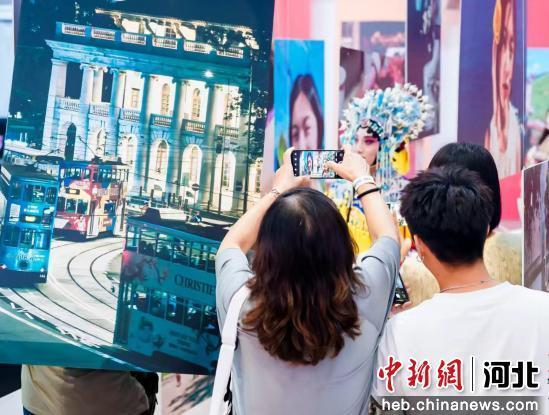 图为游客在摄影展上参观拍照。 王倩倩 摄