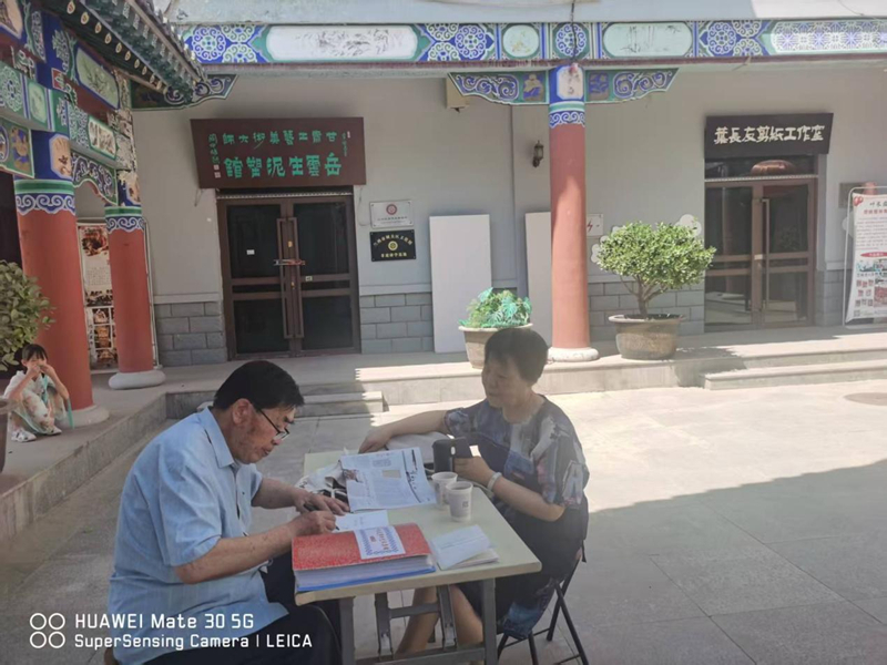 叶长友在剪纸工作室门外院子里讲述剪纸人生