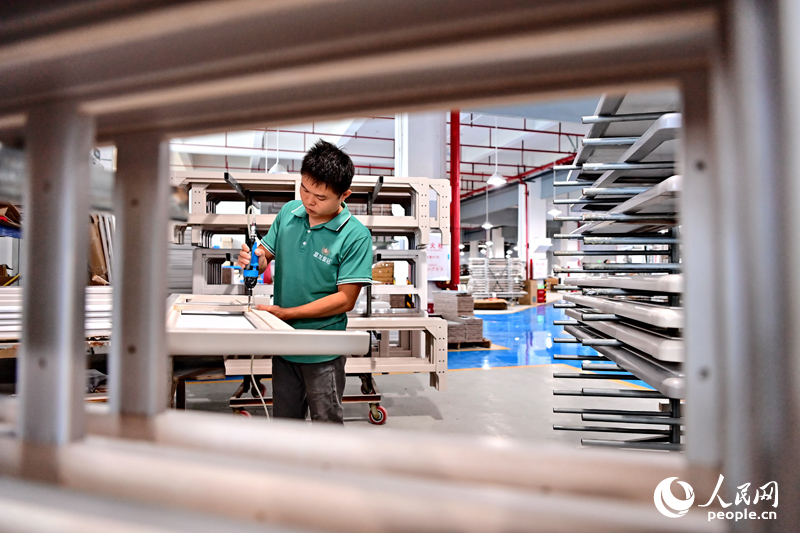 9月16日，江西富龙皇冠实业有限公司生产车间内，工人在组装实木床架。（朱海鹏摄）