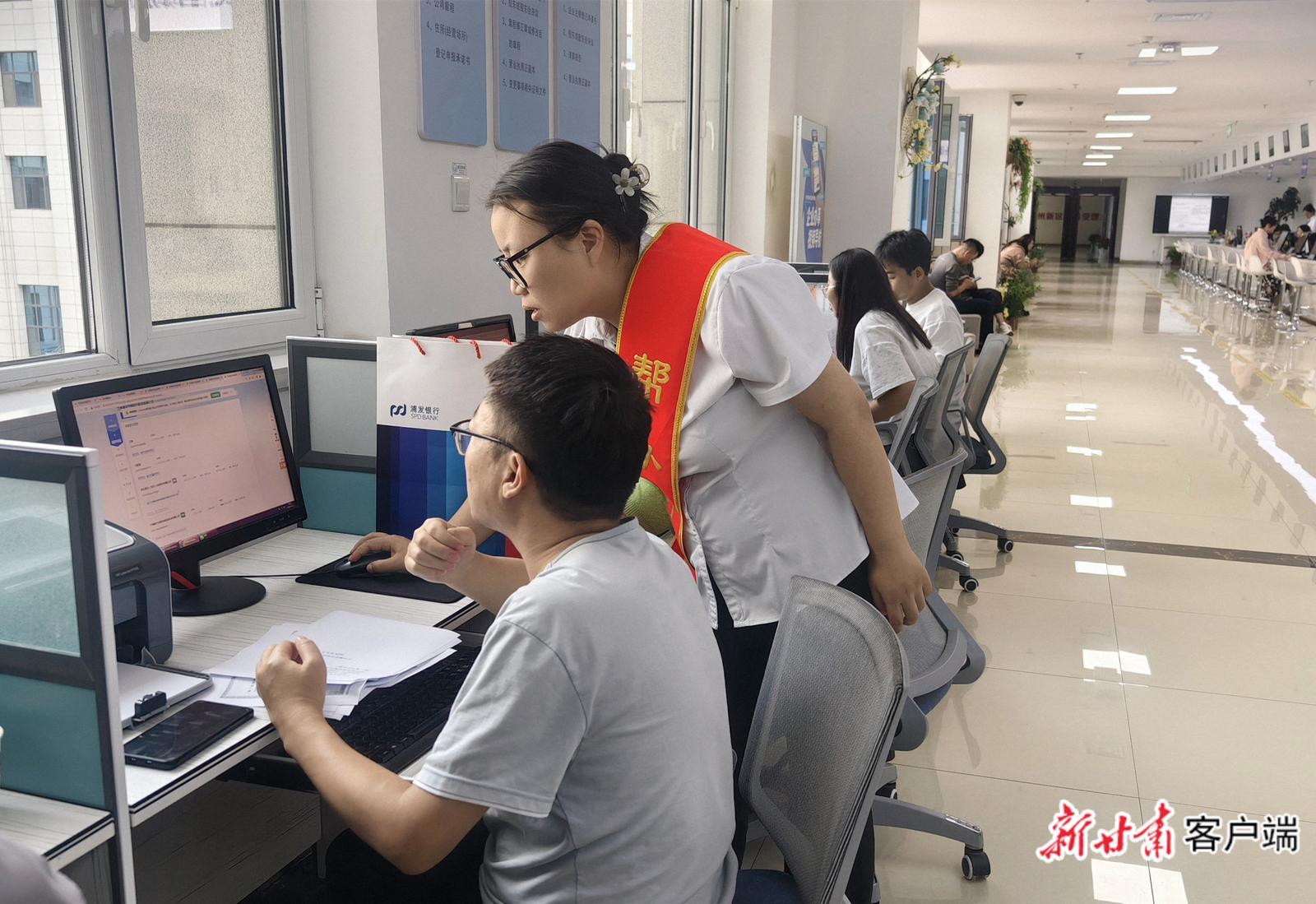 兰州新区商务和市场监督管理局综合服务大厅工作人员帮助群众办事 新甘肃·甘肃日报记者 魏晓倩 摄