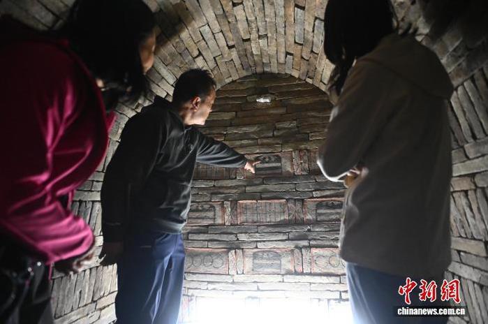 9月24日,在位于甘肃省嘉峪关市的嘉峪关新城魏晋墓群六号墓内,游客参观画像砖。中新社记者 李亚龙 摄