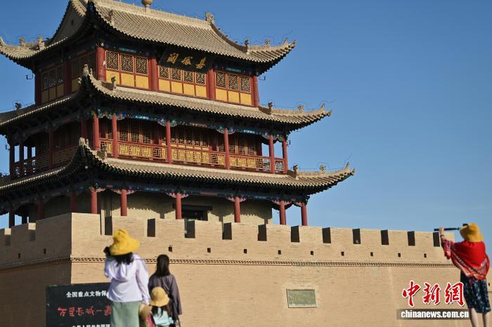 9月23日，甘肃省嘉峪关市嘉峪关关城文物景区内，游人参观拍摄嘉峪关城楼。近期，当地官方以“金色光影启航　引爆双节消费——中国&middot;嘉峪关国际短片电影周赋能文旅消费黄金季”为主题，拉开国庆与中秋假期的文旅活动序幕。官方整合关城等旅游资源打出“优惠组合拳”迎双节，自9月22日至10月8日推出“早鸟特惠”、“机票+景区”联动、“观演+游览”套餐等，切实降低游客出行成本，提升游览体验。中新社记者　李亚龙　摄