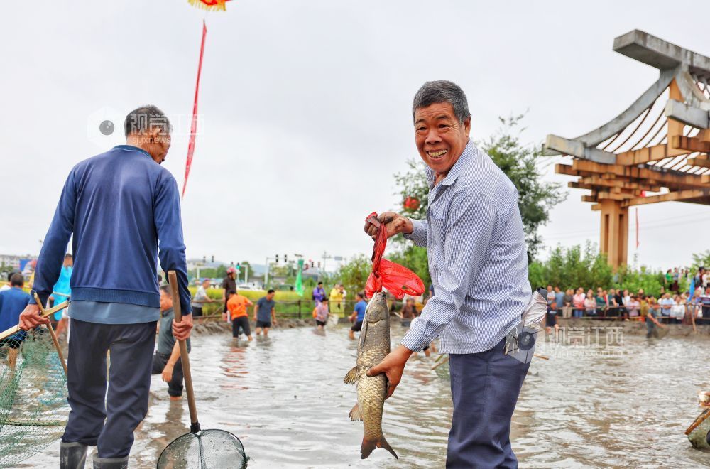 选手在农民趣味运动会项目“混水捉鱼”参赛中。