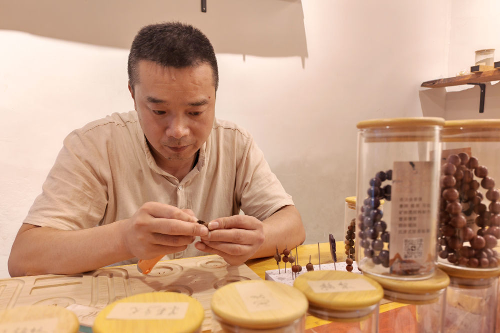 9月19日,“敦煌时见”非遗工坊负责人丁磊正在工坊内制作合香珠。新华社记者 崔翰超 摄