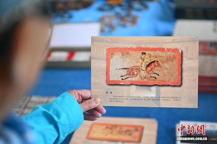 9月24日,位于甘肃省嘉峪关市的嘉峪关新城魏晋墓群展厅内,游客参观《驿使图》画像砖文创产品。《驿使图》也作为中国邮政“形象大使”而闻名。中新社记者 李亚龙 摄