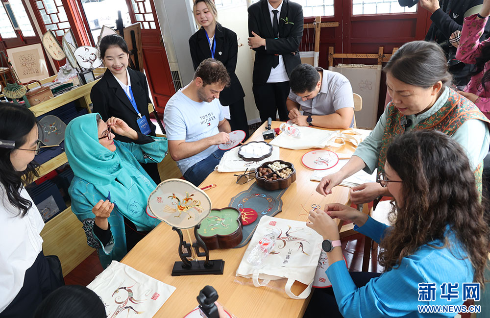 外国青年学习体验楚绣技艺。新华网连迅摄