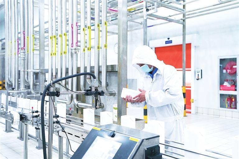 传祁乳业员工检查流水线上的产品包装情况