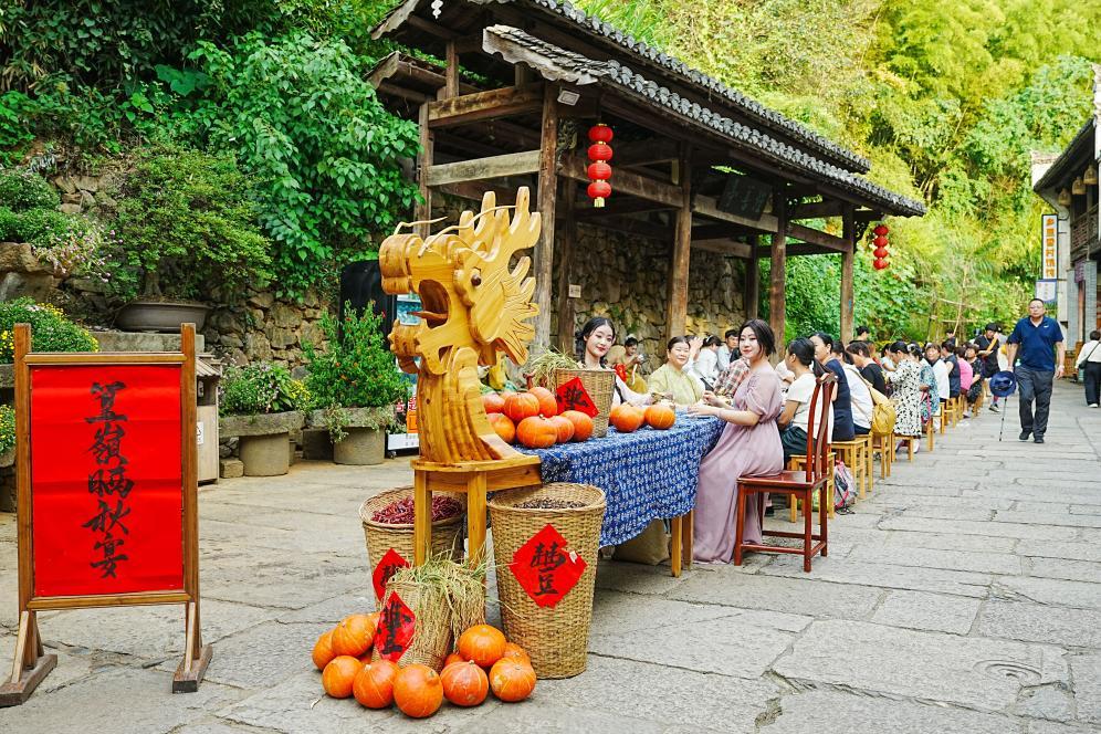 傍晚时分,天街丰收晒秋宴开席,游客们享美食、庆丰收。新华网发