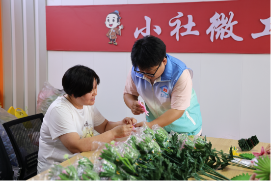 社工手把手耐心指导新加入的居民制作手工花。 吴梦莹 摄