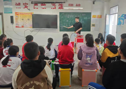 支教团成员为梓山中心小学鼓号队小队员讲解演奏知识与技能。