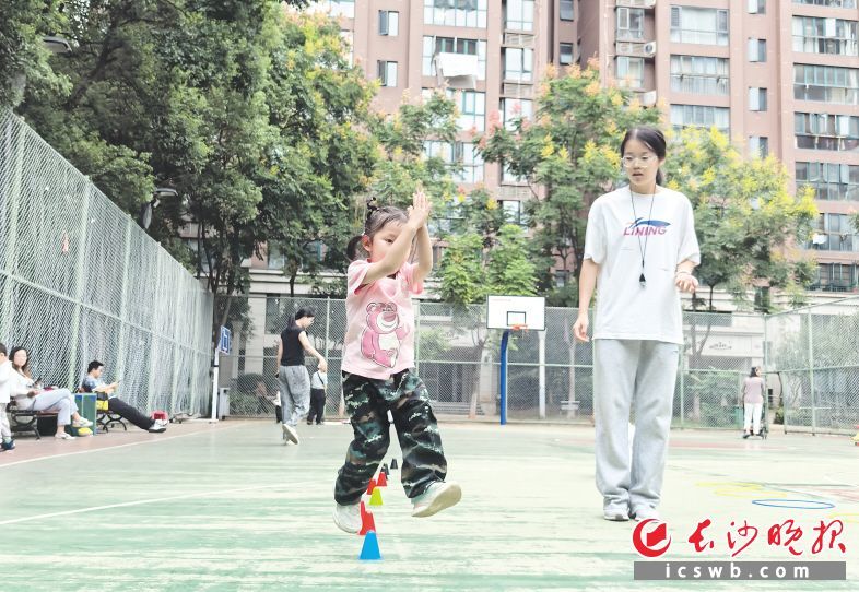 小左教练在指导孩子练习双脚跳小标志桶。受访方供图