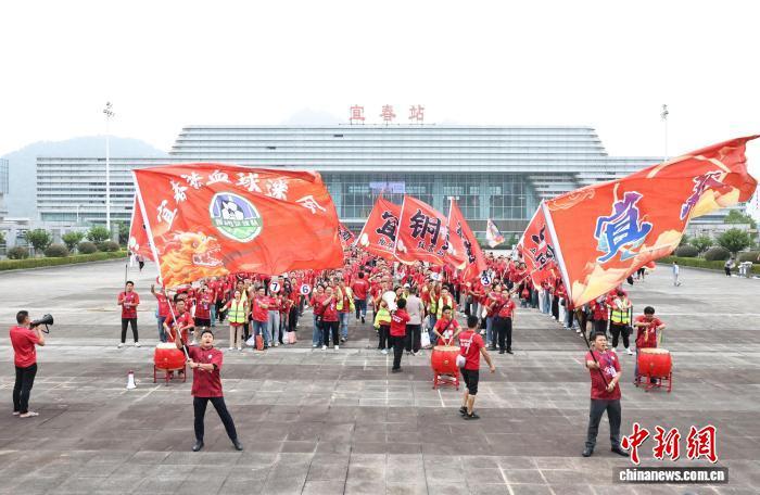 图为9月21日，宜春队球迷在宜春站站前广场集合并摇旗助威。万明轩 摄