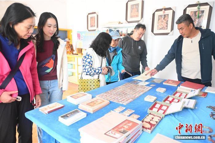 9月24日,位于甘肃省嘉峪关市的嘉峪关新城魏晋墓群展厅内,游客参观挑选画像砖连环画的文创产品。中新社记者 李亚龙 摄