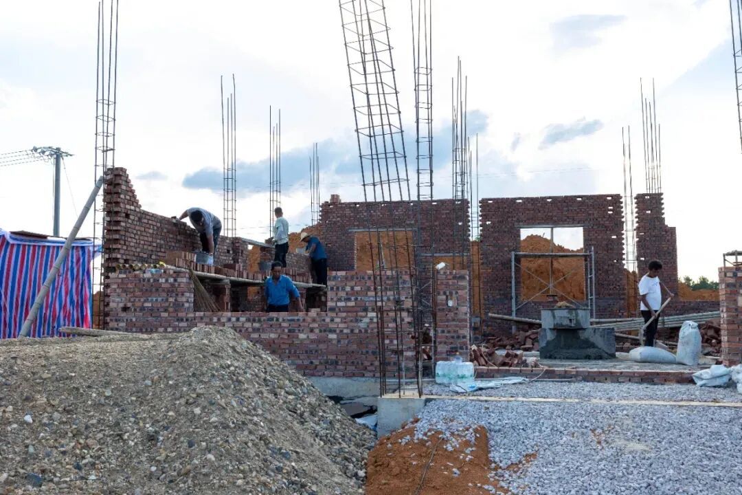 移民户在自家的建房工地忙碌