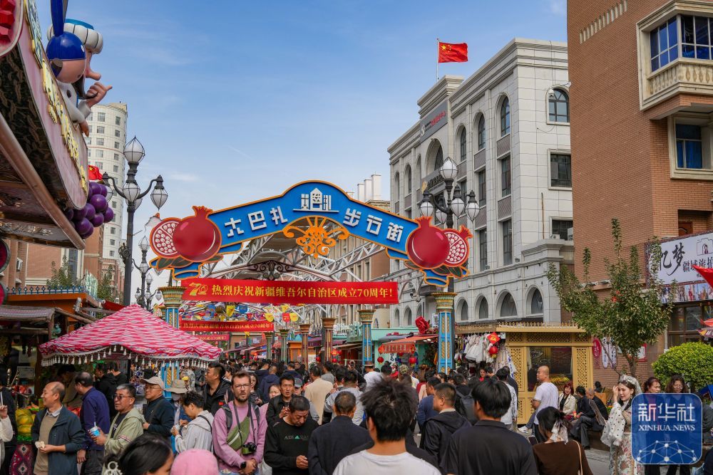 ↑ 10月1日,游客在新疆乌鲁木齐国际大巴扎游玩。新华社记者 徐宏岩 摄