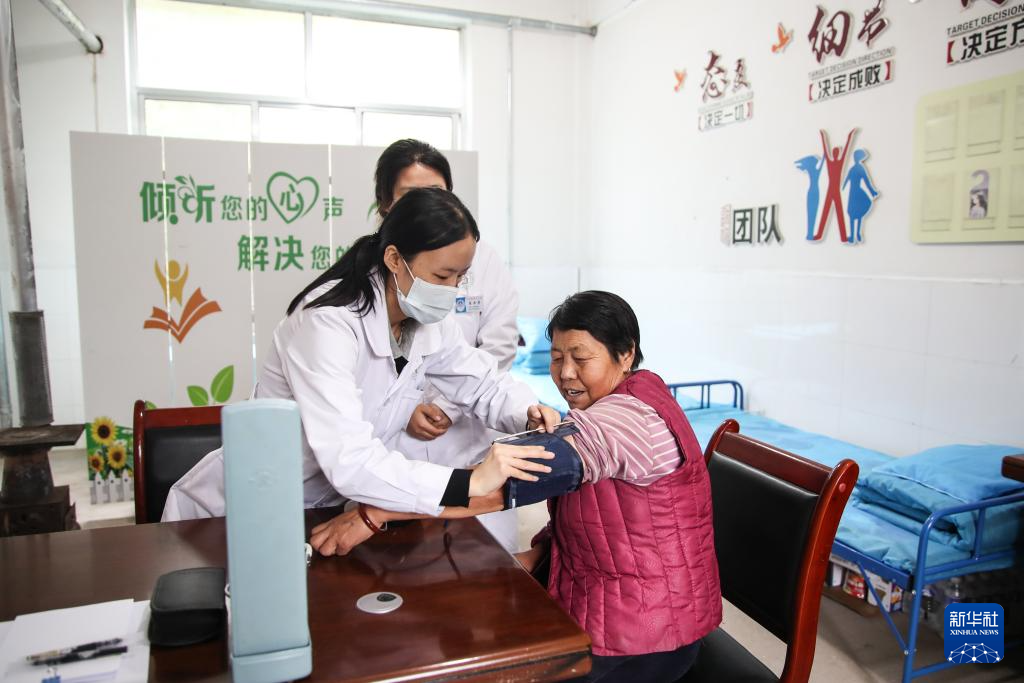 9月28日，在定西市漳县木林小学安置点医疗点，医护人员为受灾群众量血压。