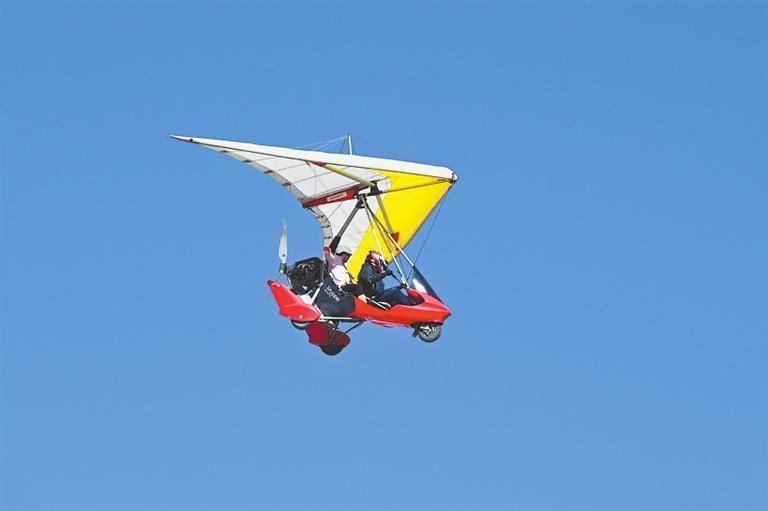 游客在敦煌市鸣沙山月牙泉景区乘坐动力滑翔机　新甘肃&middot;甘肃日报通讯员　张晓亮