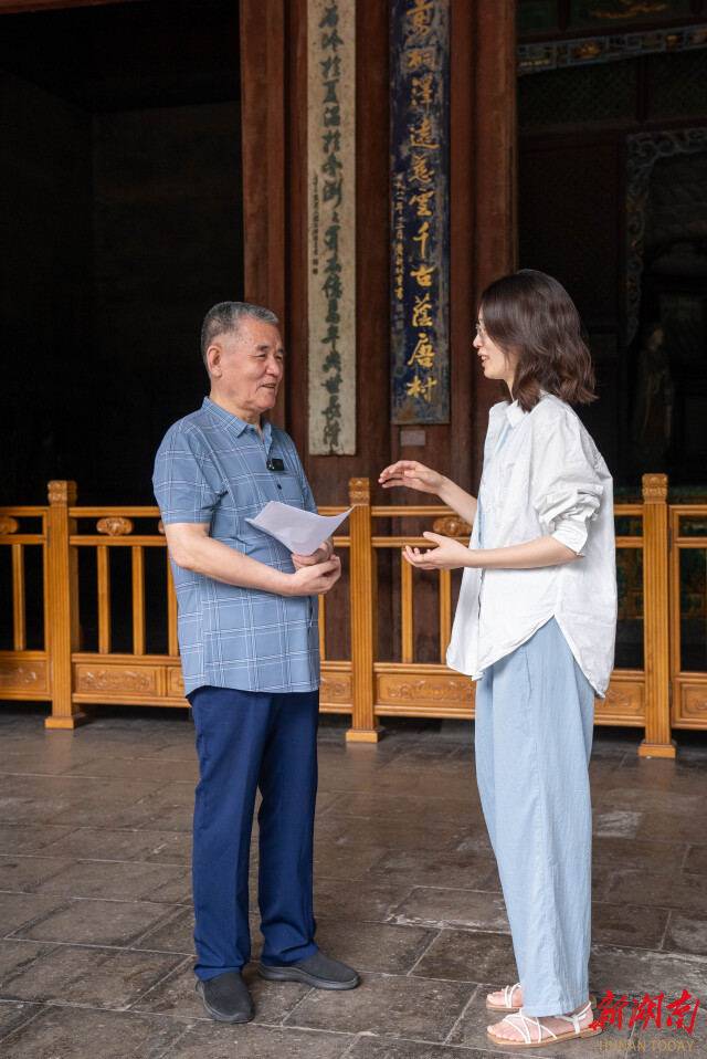 白平（左）为湖南日报记者解联。