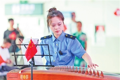 9月30日，鹰潭火车站举办文艺“快闪”活动迎国庆。图为车站工作人员正在为旅客进行古筝演奏。　　胡 齐摄