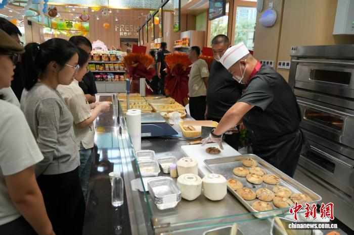 图为顾客正在体验新推出的“生鲜食品优选+餐饮即时体验”一站式购物服务。俱凝搏 摄