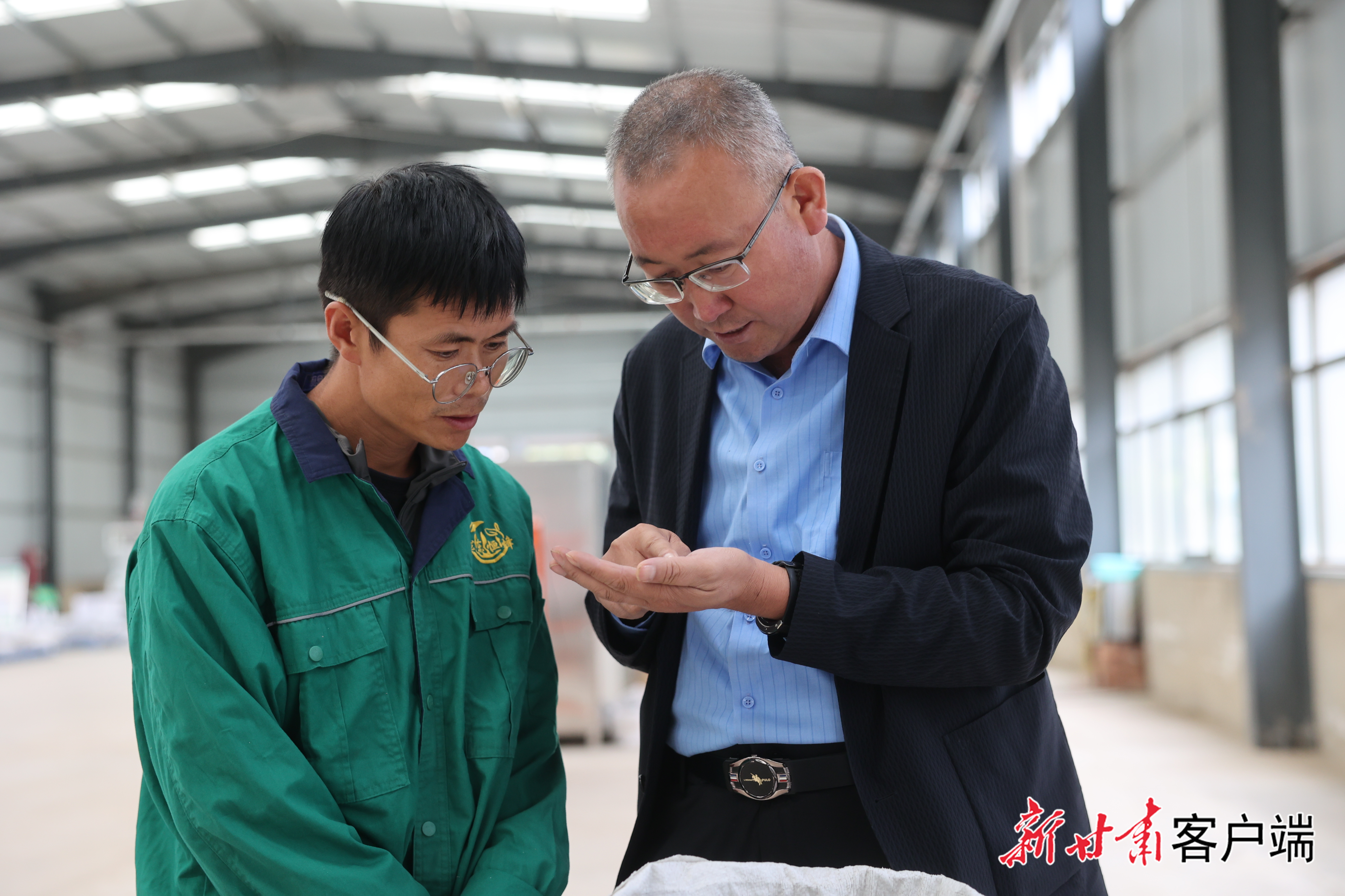 姚文智(右)与同事商量中药材加工事宜 本文图片均由受访者提供