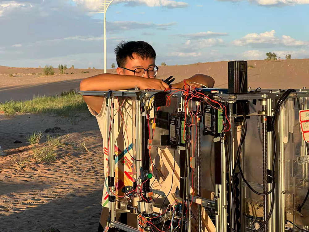 2024年暑假,张昊在沙漠调试机器。