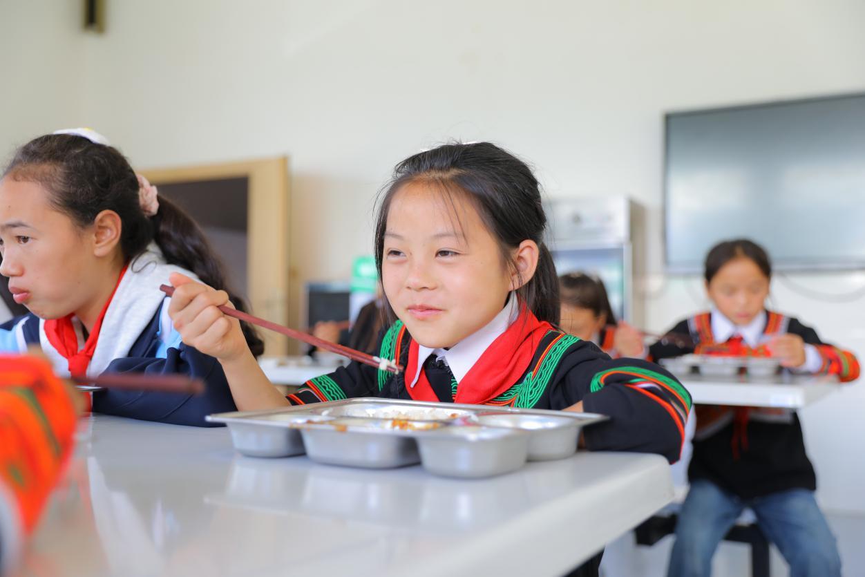 美姑县荞麦花开儿童之家的学生正在仑美爱心食堂用餐