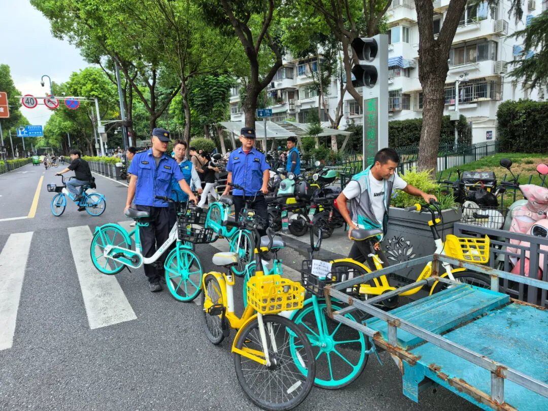 建邺城管执法人员在水西门大街附近整理共享单车（建邺区城管局供图）