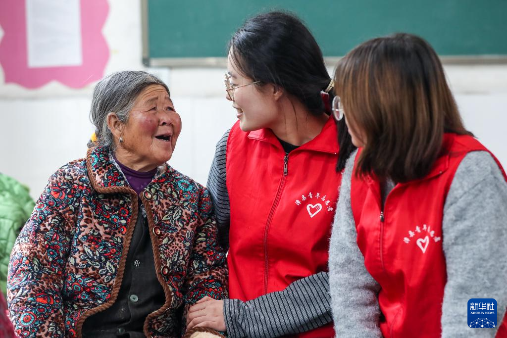 9月28日，在定西市漳县木林小学安置点宿舍内，志愿者与受灾群众交流。