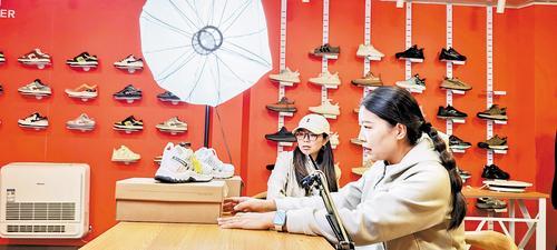9月26日，位于雄安新区安新县三台镇的“三台鞋匠”品牌运营中心内，主播正在向网友介绍一款本地鞋企生产的休闲鞋。本报记者 曹 铮摄