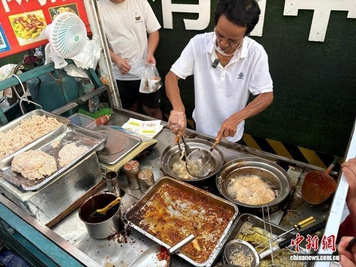 “雞排哥”李俊永正在為食客炸制雞排。記者 李韻涵 攝