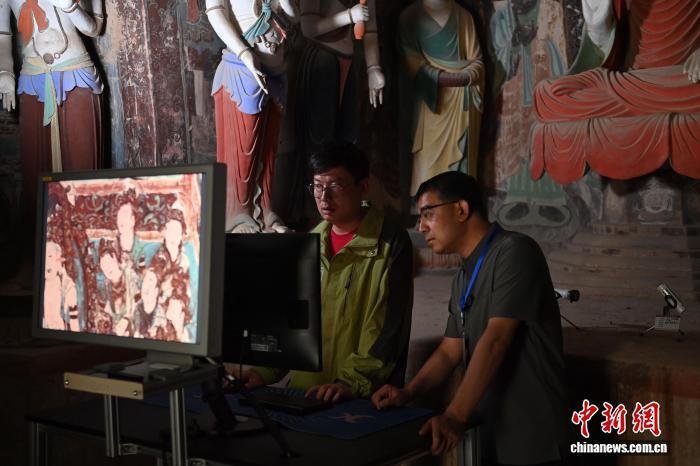 2024年6月5日，敦煌莫高窟内，敦煌研究院文物数字化研究所工作人员进行敦煌壁画数字化图像现场检查工作。（资料图）中新社记者　李亚龙　摄