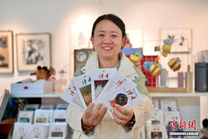 9月29日，甘肃兰州，读者杂志社品牌发展部设计师展示《读者》杂志系列文创产品明信片。九美旦增　摄