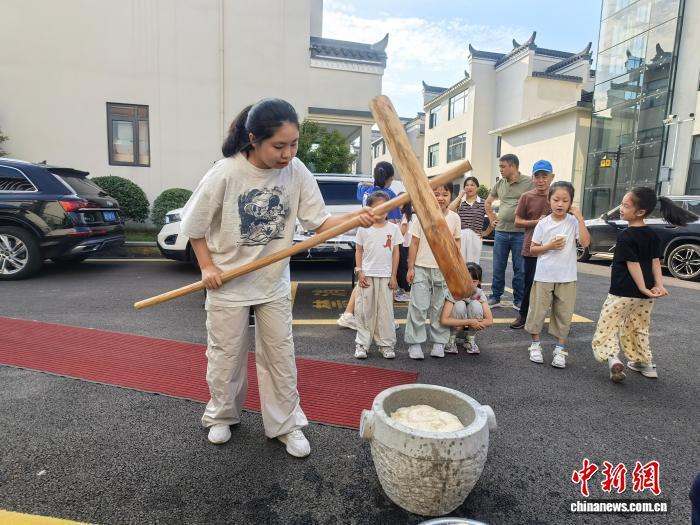 正在體驗“打麻糍”的游客。　賴強平 攝