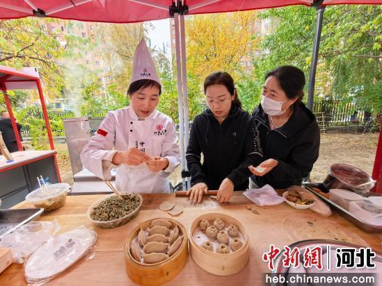 活动现场,市民与莜面手艺人学习制作莜面美食。 张桂芹 摄