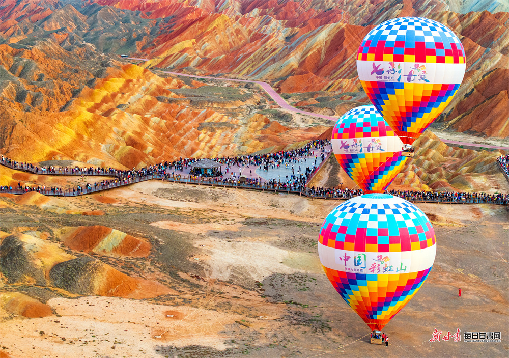 10月5日的张掖七彩丹霞景区，一场秋雨洗去尘埃，赤红如焰、橙黄似金、青灰若黛的岩层在阳光下愈发鲜亮，雨水浸润的沟壑间泛着微光，游人纷至沓来。新甘肃·每日甘肃网通讯员　杨潇　摄影报道