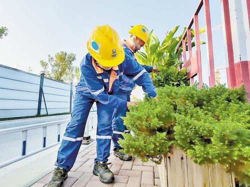 9月24日，中核雄安科技园项目建设工地，工人对护栏旁的花草进行养护。 本报见习记者 康晓博摄