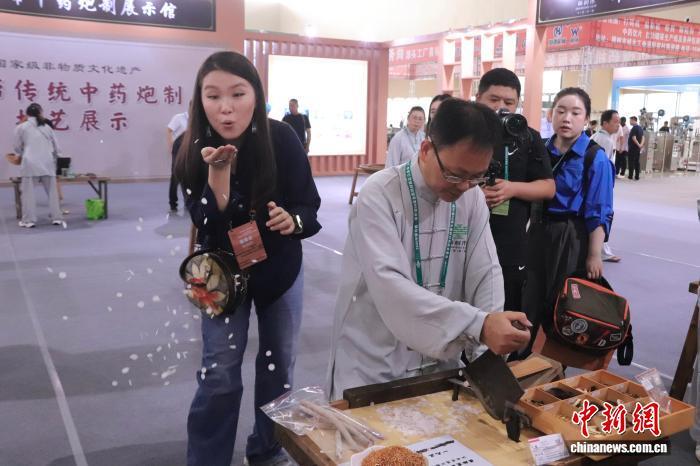 市民正在体验“樟帮传统中药炮制技艺”。 熊锦阳 摄