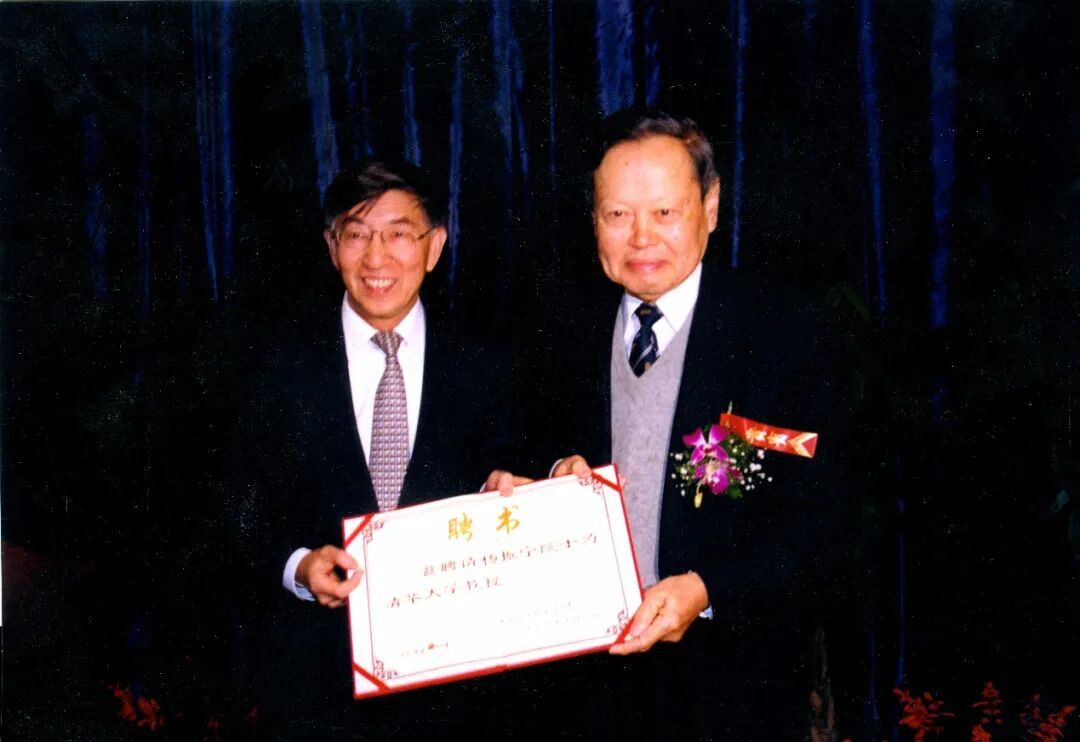 杨振宁（右一）从时任清华校长王大中手中接过清华大学聘书