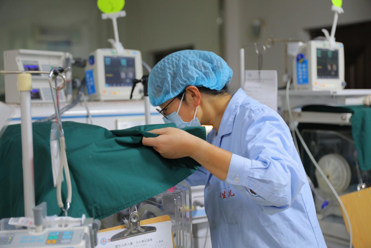 美姑县人民医院儿科副主任张虹正在新生儿病房观察新生儿