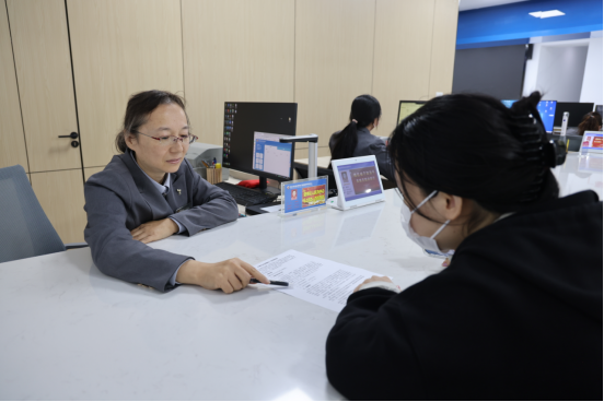 图为振头街道便民服务中心工作人员正耐心为刘萍办理子女生育登记业务。张书曼摄。